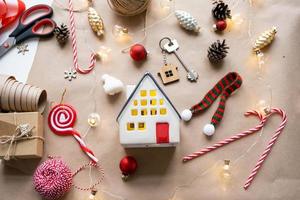 chiave per il Casa con un' portachiavi su un' accogliente casa con un' Natale arredamento disposizione. un' regalo per nuovo anno, Natale. costruzione, disegno, progetto, in movimento per nuovo Casa, mutuo, affitto e Acquista vero tenuta foto