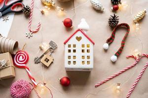 chiave per il Casa con un' portachiavi su un' accogliente casa con un' Natale arredamento disposizione. un' regalo per nuovo anno, Natale. costruzione, disegno, progetto, in movimento per nuovo Casa, mutuo, affitto e Acquista vero tenuta foto