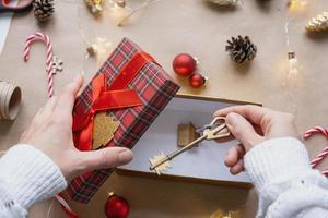 chiave per Casa con portachiavi su accogliente casa nel regalo scatola con Natale arredamento confezione. imballare presente per nuovo anno, Natale. costruzione, progetto, in movimento per nuovo Casa, mutuo, affitto, Acquista vero tenuta foto