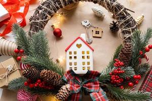 chiave per il Casa con un' portachiavi su un' accogliente casa con un' Natale arredamento disposizione. un' regalo per nuovo anno, Natale. costruzione, disegno, progetto, in movimento per nuovo Casa, mutuo, affitto e Acquista vero tenuta foto