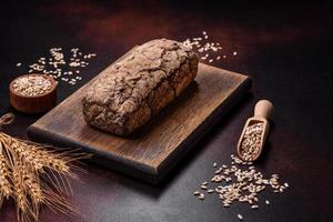 un' pagnotta di Marrone pane con cereali di cereali su un' di legno taglio tavola foto