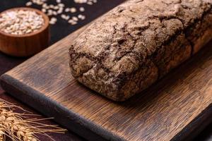 un' pagnotta di Marrone pane con cereali di cereali su un' di legno taglio tavola foto