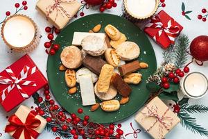 superiore Visualizza di torrone Natale dolci, mantecados e polvoroni con Natale ornamenti su un' piatto. assortimento di Natale dolci tipico nel Spagna foto