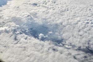 mozzafiato al di sopra di nuvole Visualizza a partire dal aereo finestra, di spessore bianca blu nuvole sembra piace morbido schiuma foto