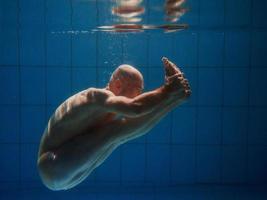 atletico sport uomo subacqueo nel il nuoto piscina. gli sport, yoga, gratuito immersione concetto foto