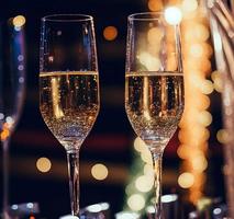 Champagne bicchieri contro vacanza luci e nuovo anno fuochi d'artificio foto