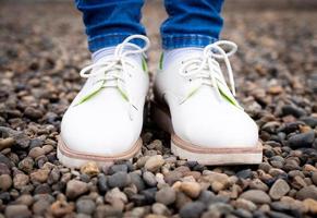 piedi di donne con scarpe da strada, in piedi sui sassi. foto