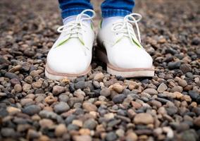 piedi di donne con scarpe da strada, in piedi sui sassi. foto