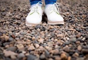 piedi di donne con scarpe da strada, in piedi sui sassi. foto