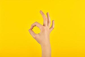 del bambino mano mostrando consenso con dita. figura su un' giallo sfondo. ok. foto
