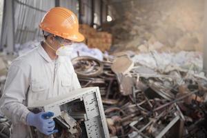 lavoratore nel raccolta differenziata industria pianta elettronico rifiuto gestione di lavoratore nel il uniforme. foto