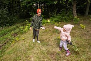 fratello con il suo poco sorella giocare nel autunno foresta catturare e lanciare palla gioco. foto