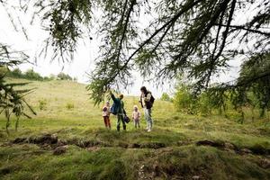 madre e sua bambini escursioni a piedi depressione foresta. foto