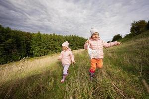 sorelle avendo divertimento e correre all'aperto vicino foresta. foto