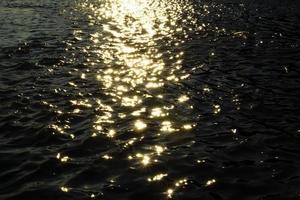 riflessione di luce del sole su un' acqua durante un' tramonto. foto