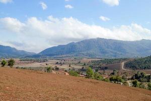 rurale paesaggio con montagne, i campi e villaggio su sfondo di blu nuvoloso cielo. xieng khouang Provincia, Laos. foto