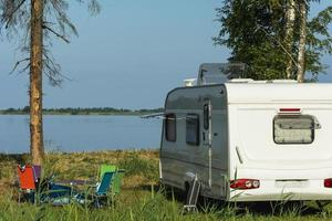 camper trailer nel natura su il sfondo di il lago, turismo, viaggiare, all'aperto ricreazione, attivo stile di vita foto