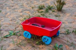 giocattolo colorato figli di carrello con coni su il sabbia foto