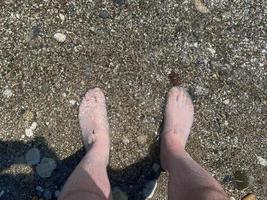 Basso sezione di uomo in piedi su spiaggia foto