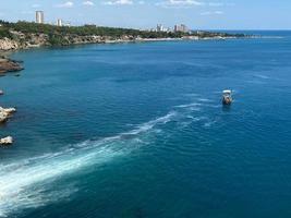 Visualizza di ricorrere con sabbioso spiaggia e galleggiante il motore Barche foto