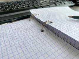uno carta bloc notes con spirale raccoglitore e vuoto lenzuola vicino nero plastica penna bugie di blu ufficio tavolo. superiore Visualizza. copia spazio per foto
