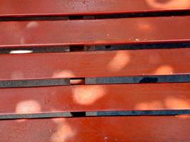 panchina riposo la zona fatto di nero Marrone legna e ferro da stiro, luminosa blu cielo nel il giardino di il città di madiun Indonesia. foto