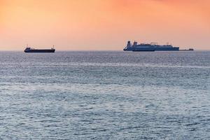 carico navi e chiatta a bellissimo tramonto. sorprendente sera paesaggio marino, mozzafiato viaggio Visualizza, copia spazio. ancoraggio per navi foto