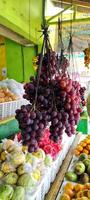 parecchi grappoli di uva sospeso nel il frutta negozio, foto prese a partire dal il lato angolo