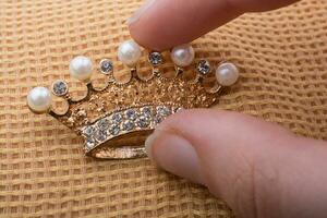 modello corona con perle in mano