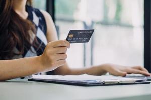 uomo d'affari mano utilizzando il computer portatile compter con Tenere credito carta pagamenti in linea shopping o attività commerciale. foto