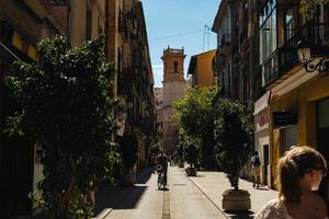 valencia, spagna, 2017-uomo in bicicletta in un vicolo trafficato foto