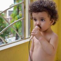 carino poco ragazzo shivaay sapra a casa balcone durante estate volta, dolce poco ragazzo servizio fotografico durante giorno luce, poco ragazzo godendo a casa durante foto sparare