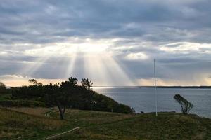 su il costa di hundest. sole raggi rompere attraverso il drammatico cielo attraverso il nuvole foto