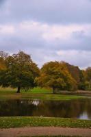 Frederiksborg castello parco con potente deciduo alberi, riflessa nel il creato lago. foto