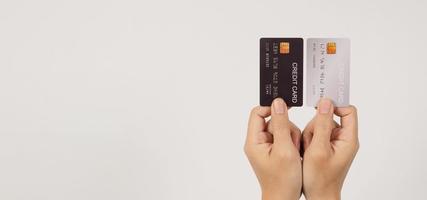 mano è hold Due credito carte. nero e argento colore credito carte isolato su bianca sfondo. foto