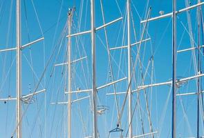 sagome di incontro yachts nel il marina contro il fondale di un' chiaro blu cielo, un idea per un' sfondo o notizia di yachting foto