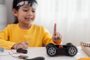 gli studenti asiatici imparano a casa a codificare auto robot e cavi di schede elettroniche in stelo, vapore, matematica ingegneria scienza tecnologia codice informatico in robotica per bambini concetto. foto