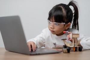 gli studenti asiatici imparano a casa a codificare auto robot e cavi di schede elettroniche in stelo, vapore, matematica ingegneria scienza tecnologia codice informatico in robotica per bambini concetto. foto