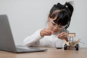 gli studenti asiatici imparano a casa a codificare auto robot e cavi di schede elettroniche in stelo, vapore, matematica ingegneria scienza tecnologia codice informatico in robotica per bambini concetto. foto