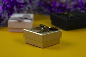 meraviglioso d'oro regalo scatola con nastri sfondo su giallo bg, un' messa a fuoco d'oro scatola, impostato di regalo scatole su giallo sfondo. foto