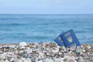 Due biometrico ucraino passaporti su mare riva sfondo foto