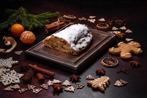 Natale torta Stollen con marzapane, frutti di bosco e noccioline su un' buio calcestruzzo sfondo foto