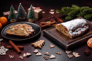 Natale torta Stollen con marzapane, frutti di bosco e noccioline su un' buio calcestruzzo sfondo foto