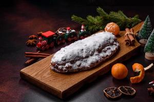 Natale torta Stollen con marzapane, frutti di bosco e noccioline su un' buio calcestruzzo sfondo foto