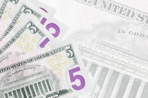 5 noi dollari fatture bugie nel pila su sfondo di grande semi trasparente banconota. astratto attività commerciale sfondo foto
