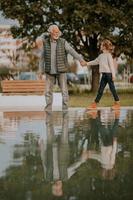 nonno la spesa tempo con il suo nipotina di piccolo acqua piscina nel parco su autunno giorno foto