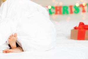 bambini spoglio piedi vicino up.festivo mood.christmas concetto, vacanza.felice nuovo anno.selettivo messa a fuoco. bambino ragazza sotto bianca soffice coperta.natale presente.bene mattina inverno concetto foto