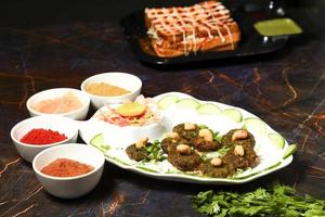 indiano lato piatto popolare chaat spuntini aloo aalù schiacciato bollito Patata tikki con speziato verde chutney e pomodoro salsa foto