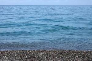 banca di ciottoli con il mare e spiaggia nel il sfondo foto