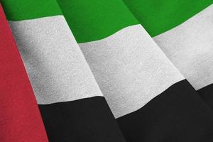 unito arabo Emirates bandiera con grande pieghe agitando vicino su sotto il studio leggero al chiuso. il ufficiale simboli e colori nel bandiera foto